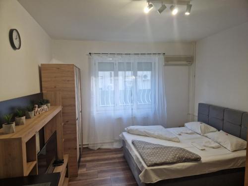 Habitación pequeña con cama y ventana en Hotel Duga, en Novi Sad