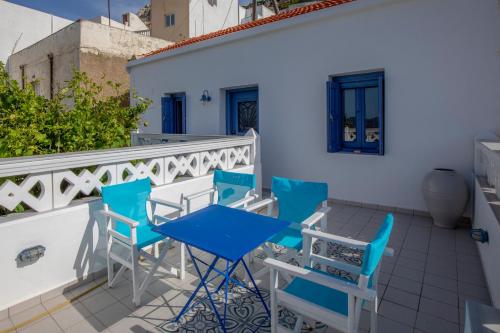 a patio with blue chairs and a table on a balcony at Thea Menetes in Karpathos Town