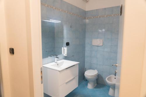 uma casa de banho com um lavatório branco e um WC. em Arena Rooms em Verona