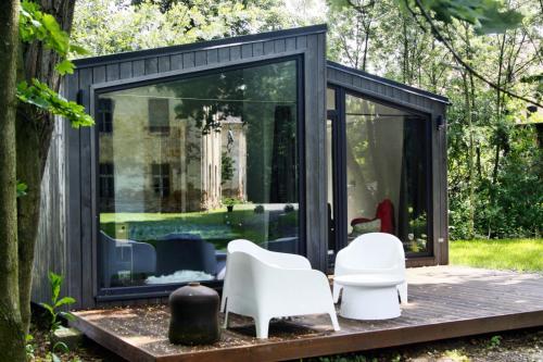 a black and white shed with white chairs in the yard at Domek Hrabiny nr 3 in Rozkochów