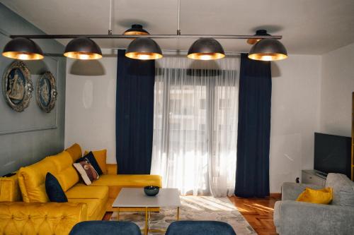 a living room with a yellow couch and blue curtains at The Impressive Apartment in Trebinje