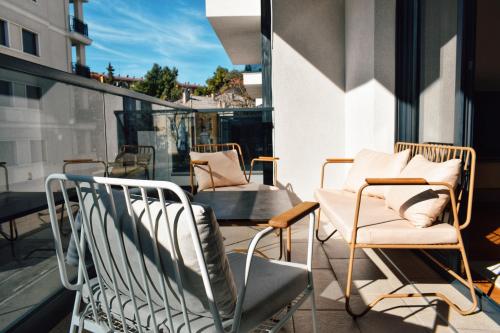 a balcony with chairs and tables on a building at The Impressive Apartment in Trebinje
