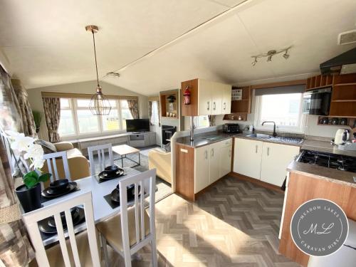 an open kitchen and living room with a table and chairs at Coral Beach - Ingoldmells - Row 89 Van 1 in Ingoldmells
