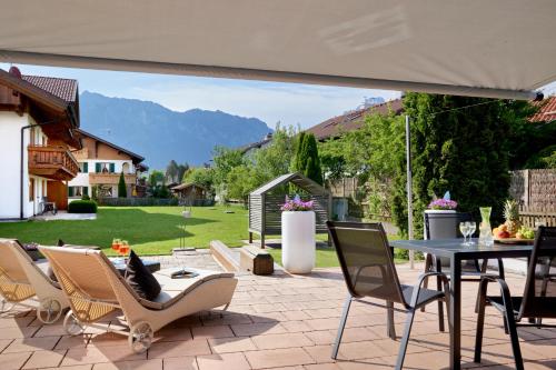 a patio with a table and chairs and a table and chairs at Maximilian Appartements in Schwangau