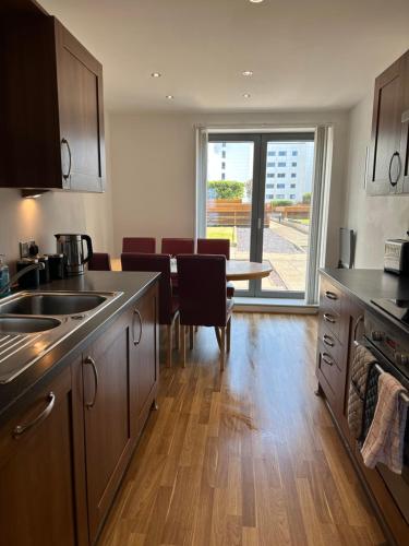 a kitchen with a table and a dining room at Stunning Waterfront Western harbour Apartment in Edinburgh