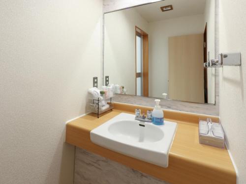 bagno con lavandino bianco e specchio di Hotel Fuji a Fuefuki