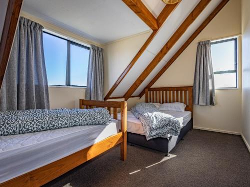 two beds in a room with windows at Three Peak Lodge - National Park Holiday Home in National Park