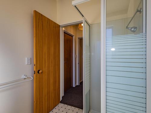 a bathroom with a glass door and a hallway at Three Peak Lodge - National Park Holiday Home in National Park