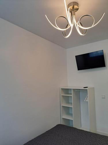 a living room with a ceiling fan and a tv at Trumpalaikė apartamentų nuoma centre (Vytauto g.) in Šiauliai