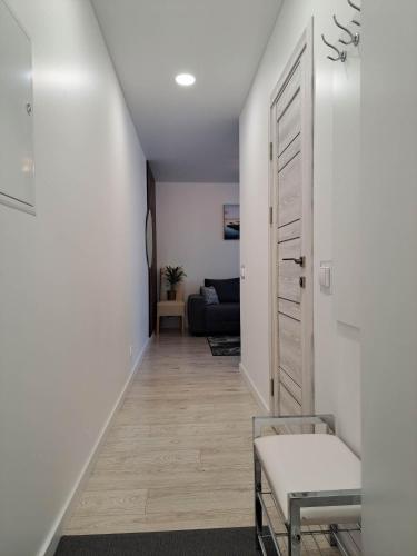 un corridoio che conduce a un soggiorno con divano di Trumpalaikė apartamentų nuoma centre (Vytauto g.) a Šiauliai