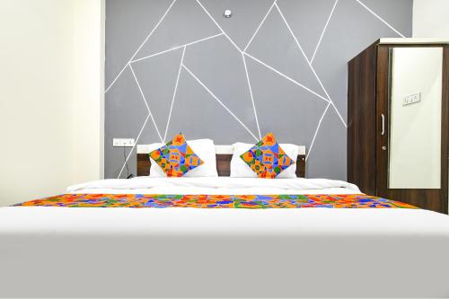 una camera da letto con un grande letto con cuscini colorati di FabExpress SP7 a Indore