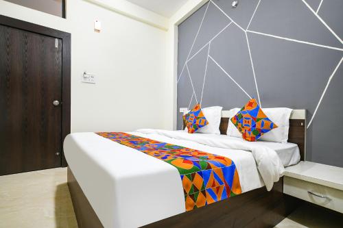 sypialnia z dużym łóżkiem z kolorowymi poduszkami w obiekcie FabExpress SP7 w mieście Indore