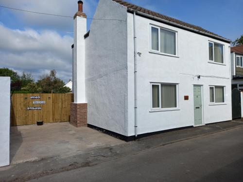 a white house on the side of a street at Pet Friendly Beautiful Detached Cottage close to Spurn Point, Easington and Withersea in Hull