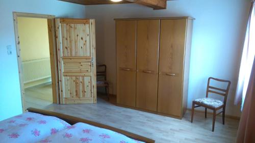 a bedroom with a bed and a cabinet and a chair at Gartenblick in Brotterode-Trusetal