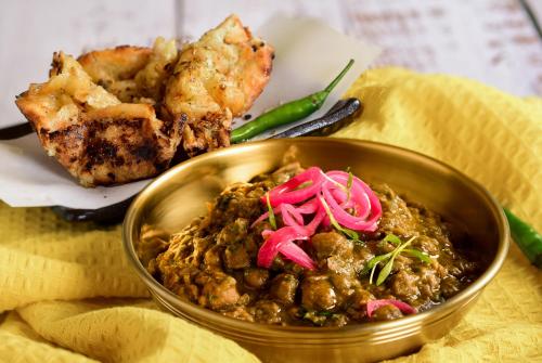 a metal bowl of food with meat and vegetables at The Serangoon House Little India, Singapore, a Tribute Portfolio Hotel in Singapore