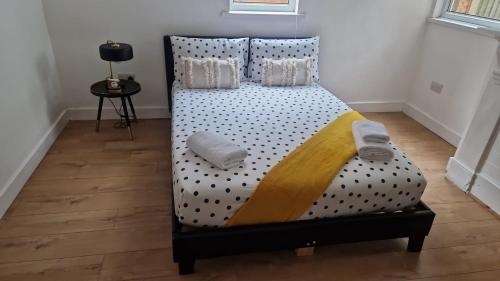 uma cama com lençóis de bolinhas e almofadas em BELLACASA GUESTHOUSE em Nottingham