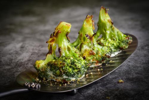 a plate of broccoli sitting on a table at The Serangoon House, Singapore, a Tribute Portfolio Hotel in Singapore
