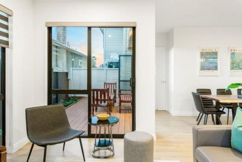 a living room with a table and chairs at Pristine Modern Central Home - Netflix - Heatpump in Auckland