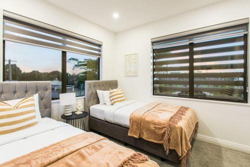 - 2 lits dans une chambre avec fenêtre dans l'établissement Pristine Modern Central Home - Netflix - Heatpump, à Auckland