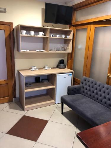 Easy Hostel في تشيرنيفتسي: غرفة معيشة مع أريكة وتلفزيون