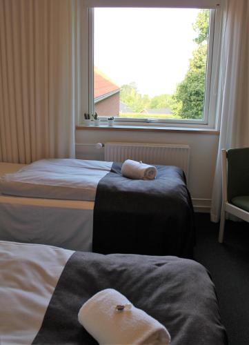 a hotel room with two beds and a window at Severin Kursuscenter og Konferencehotel in Middelfart