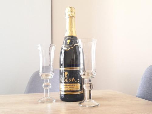 a bottle of champagne sitting on a table with two glasses at Sea Dreams Apartment in Sveti Vlas