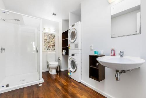 y baño con lavabo y lavadora. en Gorgeous NY Style Loft in CBD - Netflix Wifi, en Auckland
