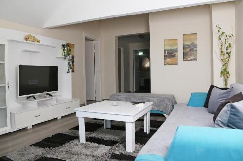 a living room with a couch and a tv at Memory Suites in Buyukcekmece