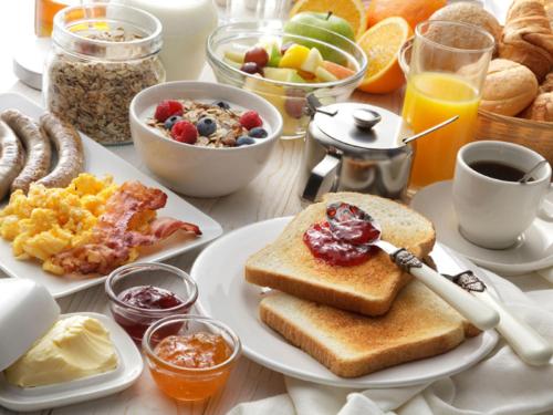 una mesa de desayuno con tostadas y una bandeja de alimentos para el desayuno en Maxwell Reserve Singapore, Autograph Collection en Singapur