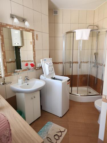 y baño con ducha, lavabo y bañera. en Apartament Piłsudskiego, en Świnoujście