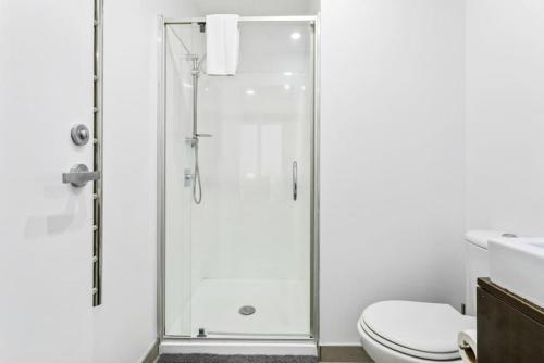 un baño con ducha y WC en Hideaway Apartment with pool and free parking, en Auckland