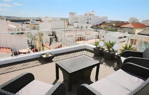 a balcony with chairs and a table on a roof at Isa SkyHouse Algarve in Portimão