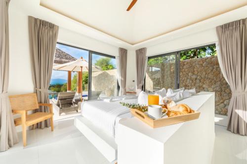 una habitación con una cama y una mesa con un gato. en Villa Mandra - Beautiful 4 Bedroom Luxury Pool Villa KBR2 en Koh Samui