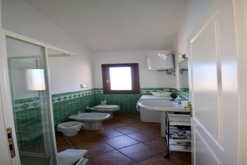 a bathroom with two toilets and a sink and a shower at Le Dimore di Nettuno in Olbia