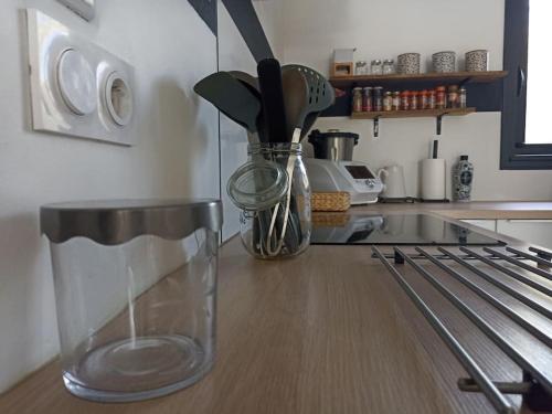 a kitchen counter with a glass vase with utensils at Superbe Villa in Villeneuve