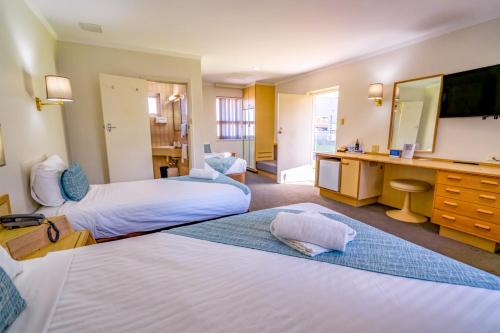 ein Hotelzimmer mit 2 Betten und einem Schreibtisch in der Unterkunft Hospitality Esperance SureStay Collection by Best Western in Esperance