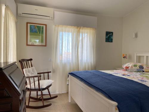 a bedroom with a bed and two chairs in it at Apartamento na Vila Senhora da Rocha in Porches