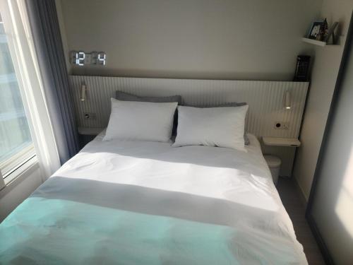 Harington Gwangan في بوسان: سرير بشرشف ووسائد بيضاء في الغرفة