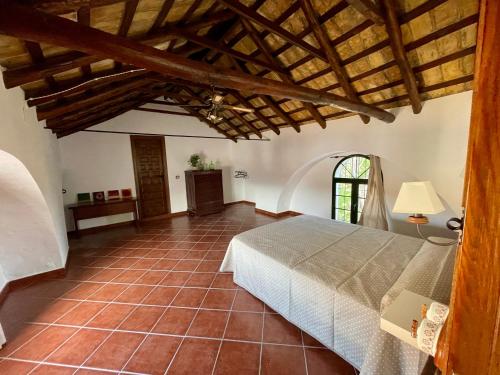 um quarto com uma cama e um tecto de madeira em Cortijo Doñana em La Puebla de Cazalla