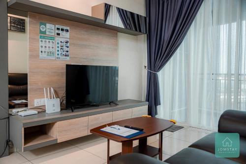 a living room with a tv and a table at JOMSTAY Majestic Ipoh Suites in Ipoh