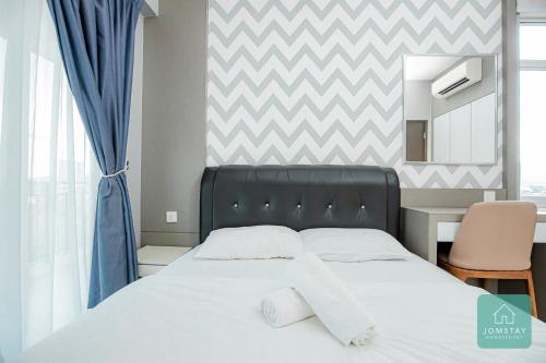 a bed in a bedroom with a chevron wall at JOMSTAY Majestic Ipoh Suites in Ipoh