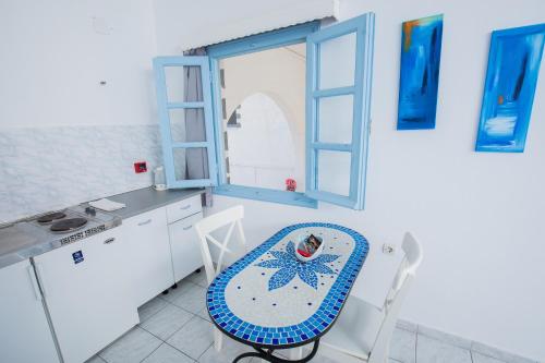 a kitchen with a table and a blue chair at Pico Bello Patmos 22 in Patmos