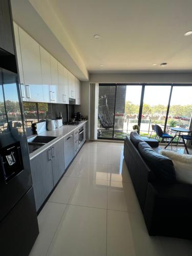 a kitchen and living room with a couch and a counter at Entire One Bedroom Apartment, Penrith in Kingswood