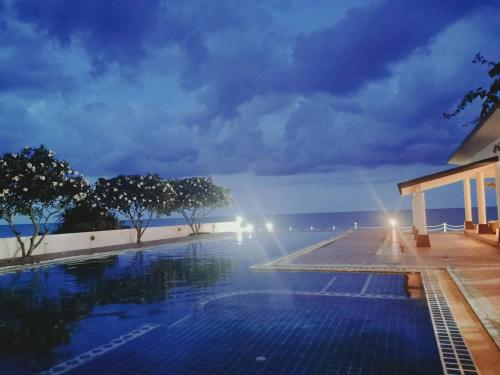 una piscina con vista sull'oceano di notte di Khanom Beach Residence 1-bedroom Mountain & Sea View a Khanom