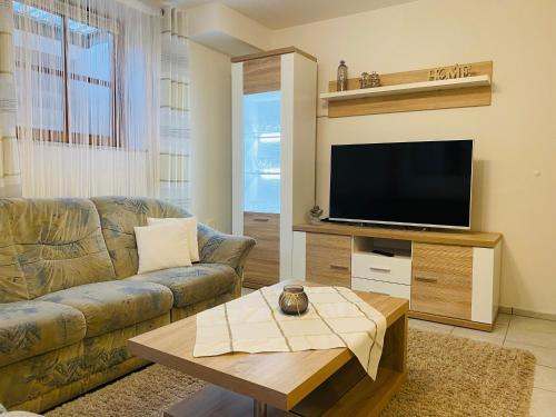 a living room with a couch and a flat screen tv at Ferienwohnung Am Berg in Pinzberg