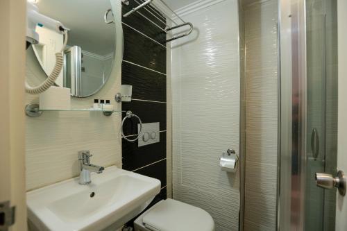 y baño con lavabo, aseo y espejo. en Grand Inova Hotel en Estambul