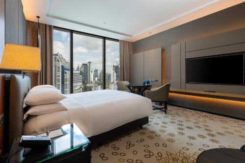 a hotel room with a large bed and a large window at Hyatt Regency Bangkok Sukhumvit in Bangkok
