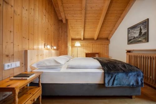 1 dormitorio con 1 cama grande y techo de madera en Villa Melitta, en San Vigilio Di Marebbe