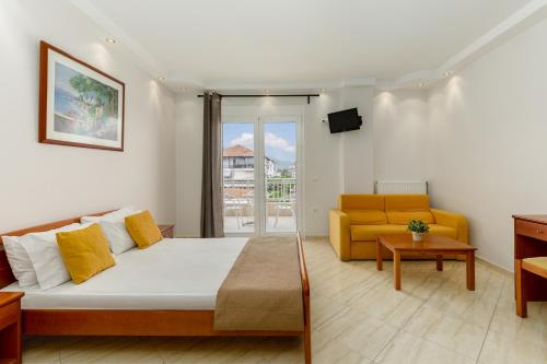 un soggiorno con letto e divano di Agyra Seaview Hotel by Panel Hospitality a Neoi Poroi