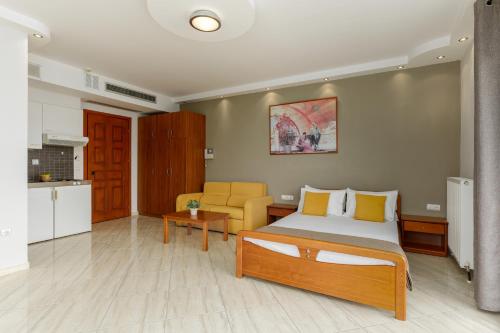 1 dormitorio con 1 cama y sala de estar en Agyra Seaview Hotel by Panel Hospitality, en Neoi Poroi